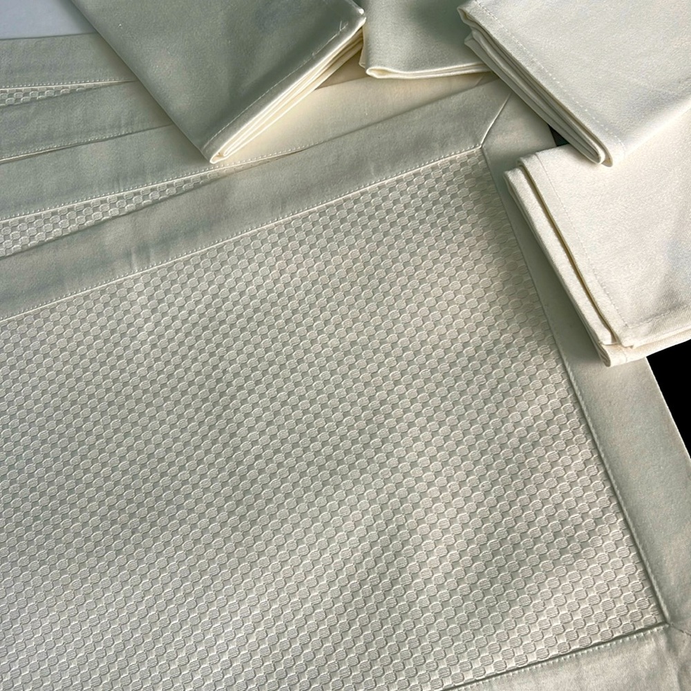 Four off white Place Mats, and matching napkins.